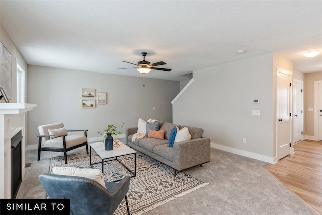 carpeted living room with ceiling fan