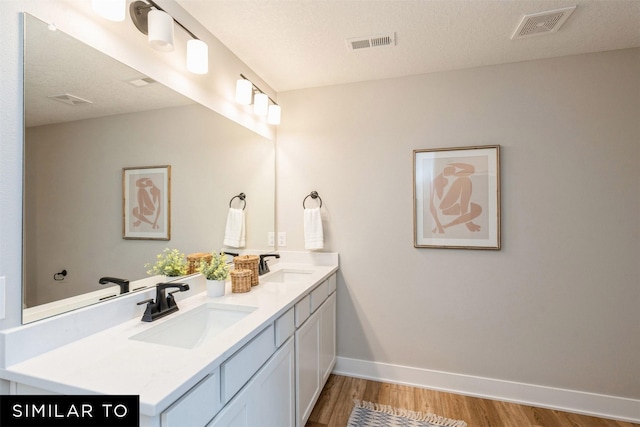 bathroom with vanity, a textured ceiling, and hardwood / wood-style floors