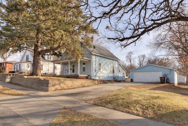 view of front of house with a front lawn, an outdoor structure, and a garage