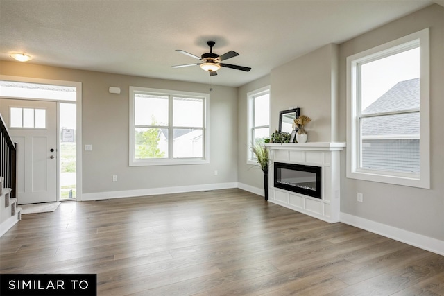 unfurnished living room featuring ceiling fan and hardwood / wood-style floors