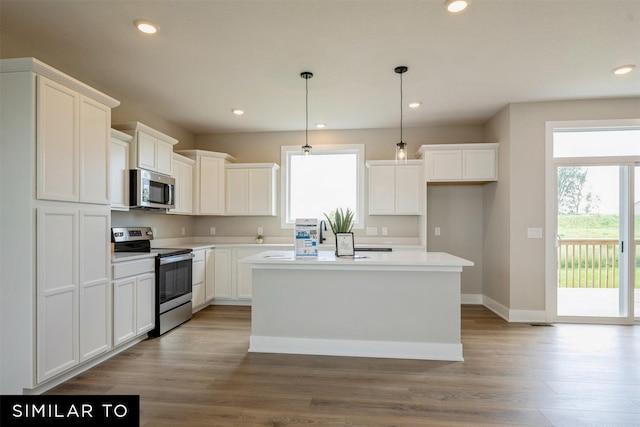 kitchen featuring white cabinets, pendant lighting, stainless steel appliances, and a kitchen island