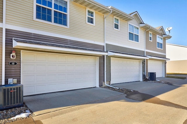 garage with central air condition unit and driveway