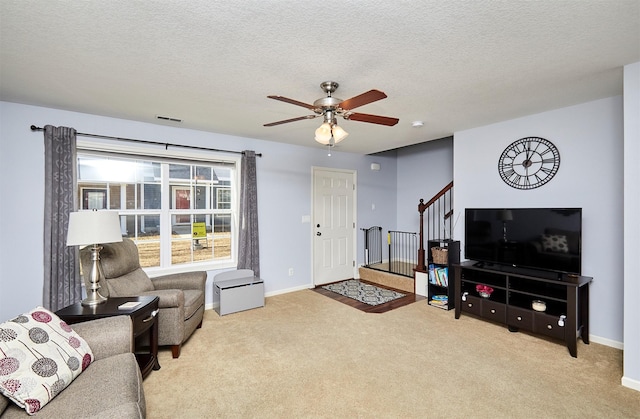 carpeted living room with stairway, visible vents, a textured ceiling, and baseboards