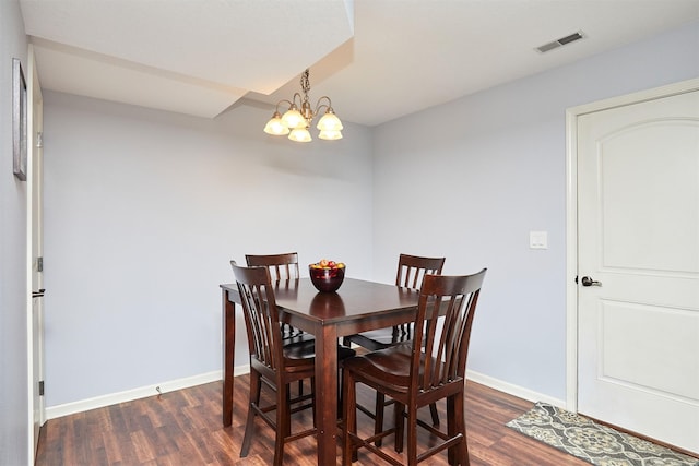 dining area featuring a notable chandelier, visible vents, dark wood finished floors, and baseboards