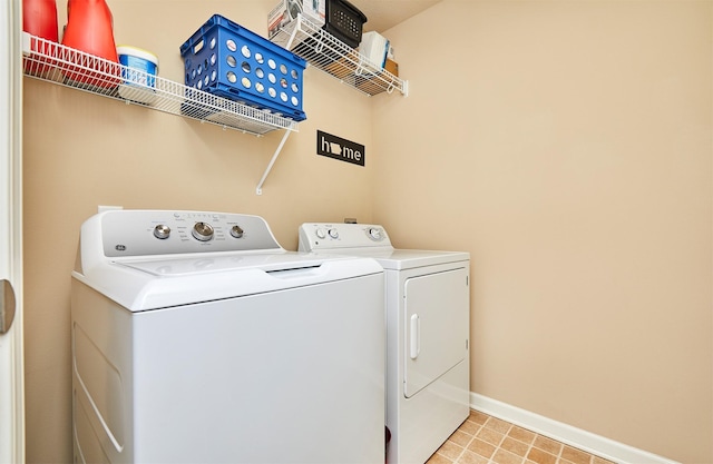 washroom with washing machine and clothes dryer, laundry area, and baseboards