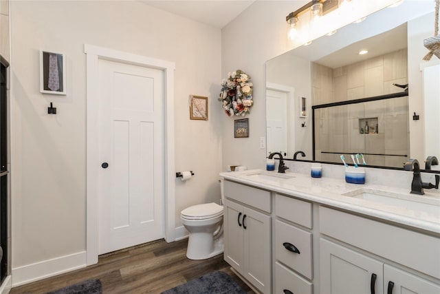 bathroom with a shower with shower door, wood-type flooring, toilet, and vanity