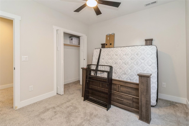 bedroom featuring light carpet, ceiling fan, and a closet