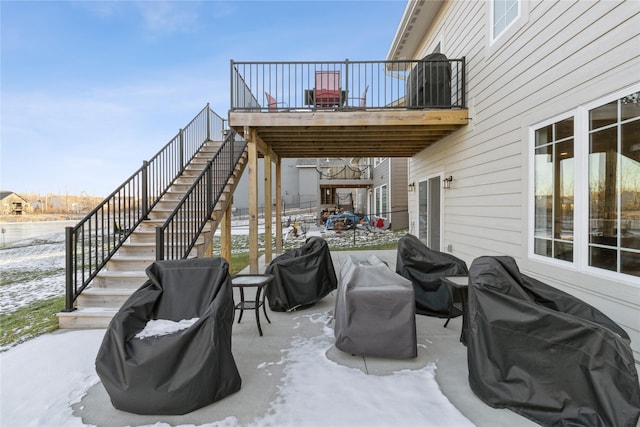 snow covered patio with a grill