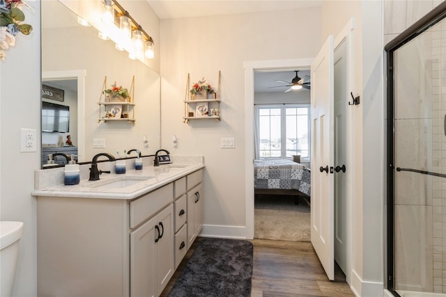 bathroom featuring toilet, ceiling fan, wood-type flooring, walk in shower, and vanity