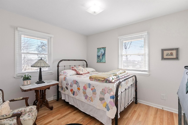 bedroom featuring a baseboard radiator and light hardwood / wood-style flooring