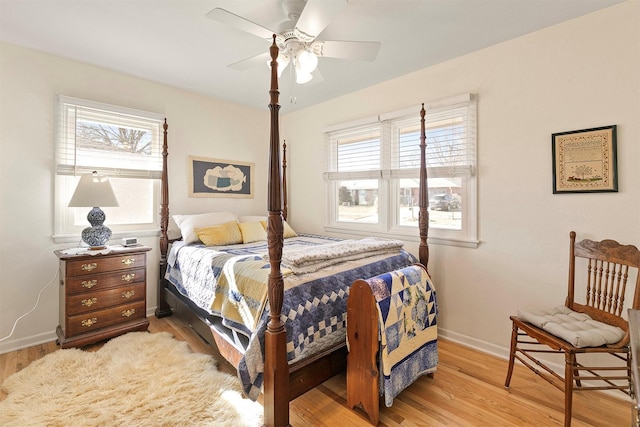 bedroom with ceiling fan, light wood-type flooring, and multiple windows