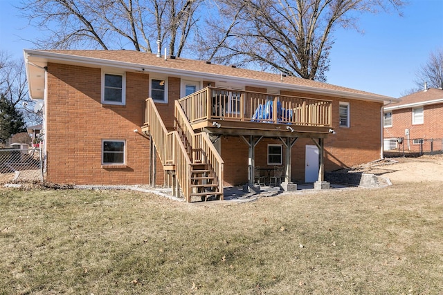 back of property with a wooden deck and a lawn