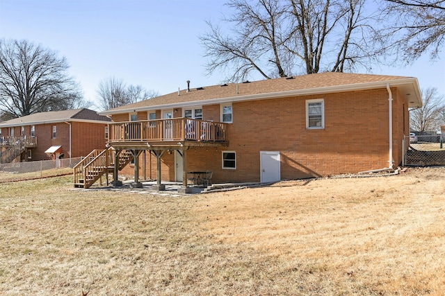 back of property with a deck, a lawn, and a patio