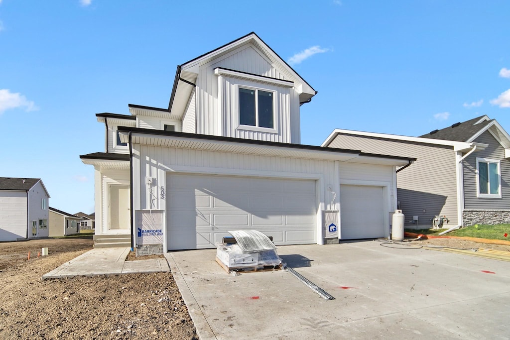 view of front of house featuring board and batten siding, an attached garage, driveway, and a garage