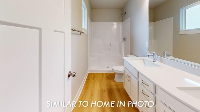 503 43rd St SW, Altoona, IA 50009 - bathroom featuring a sink, double vanity, toilet, wood finished floors, and a shower