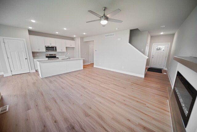 503 43rd St SW, Altoona, IA 50009 - unfurnished living room with a ceiling fan, a sink, recessed lighting, light wood-style floors, and baseboards