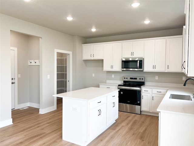 7046 SE 7th Ave, Pleasant Hill, IA 50327 - kitchen with appliances with stainless steel finishes, light wood-type flooring, light countertops, and a sink