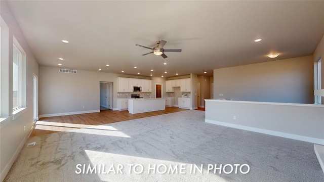 unfurnished living room featuring light hardwood / wood-style floors and ceiling fan