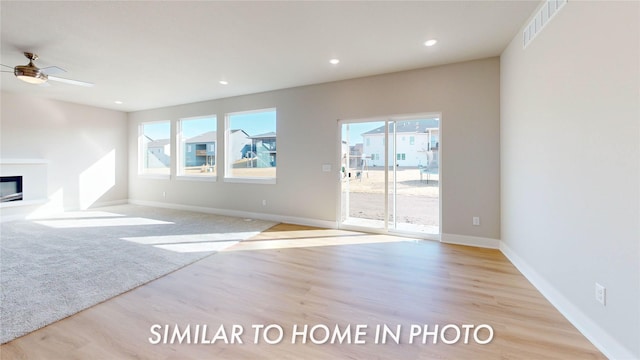 unfurnished living room with ceiling fan and light wood-type flooring