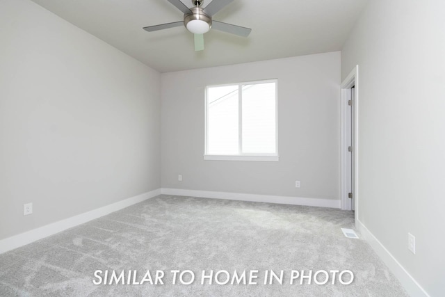 carpeted empty room with visible vents, a ceiling fan, and baseboards