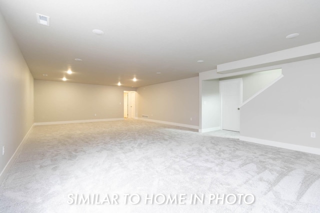 finished below grade area featuring visible vents, baseboards, and carpet