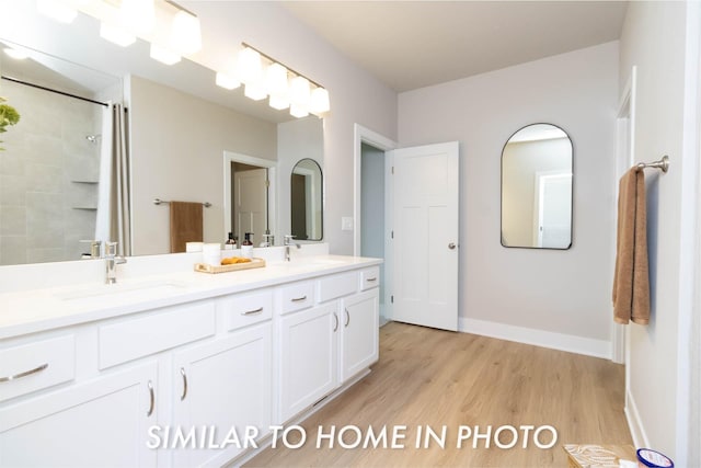 full bath featuring wood finished floors, a sink, a shower, and double vanity