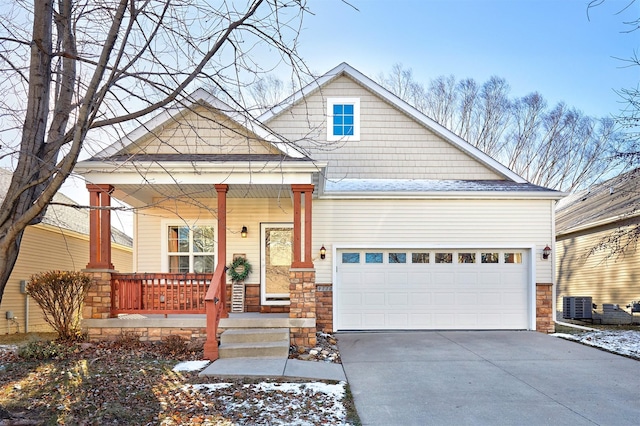 view of front of property with central AC, a garage, and a porch