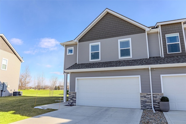 view of front of house featuring central AC, a front lawn, and a garage