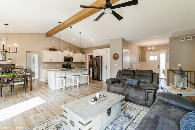 living room featuring light wood-type flooring, ceiling fan with notable chandelier, vaulted ceiling with beams, and sink