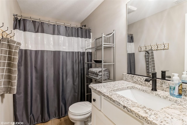 bathroom with toilet, vanity, a textured ceiling, and hardwood / wood-style floors