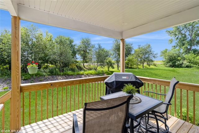 wooden terrace featuring a grill and a lawn