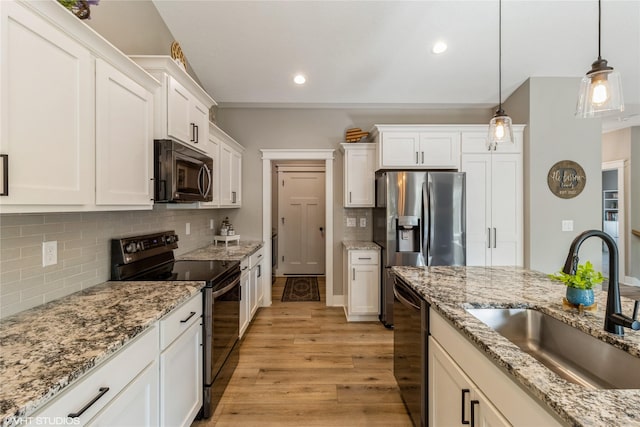 kitchen with sink, hanging light fixtures, white cabinets, and black appliances