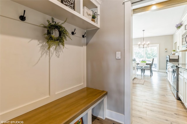 mudroom featuring a chandelier and light hardwood / wood-style flooring