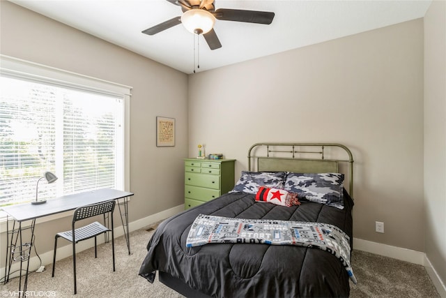 bedroom with ceiling fan, light colored carpet, and multiple windows