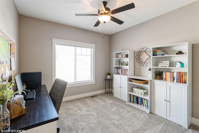 carpeted office space featuring ceiling fan