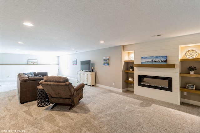 carpeted living room featuring built in shelves and a textured ceiling