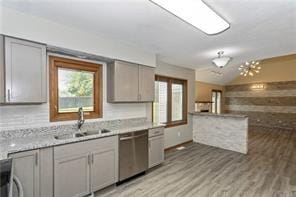 kitchen featuring light hardwood / wood-style floors, sink, stainless steel dishwasher, and gray cabinets