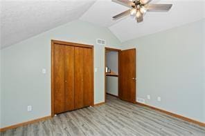 unfurnished bedroom with ceiling fan, light hardwood / wood-style floors, a closet, and lofted ceiling