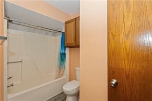 bathroom featuring toilet and shower / bath combination with curtain