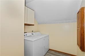 washroom featuring cabinets and washer and clothes dryer