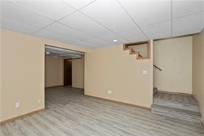 interior space with a drop ceiling and light wood-type flooring