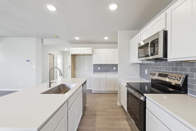 kitchen featuring appliances with stainless steel finishes, sink, white cabinets, and backsplash