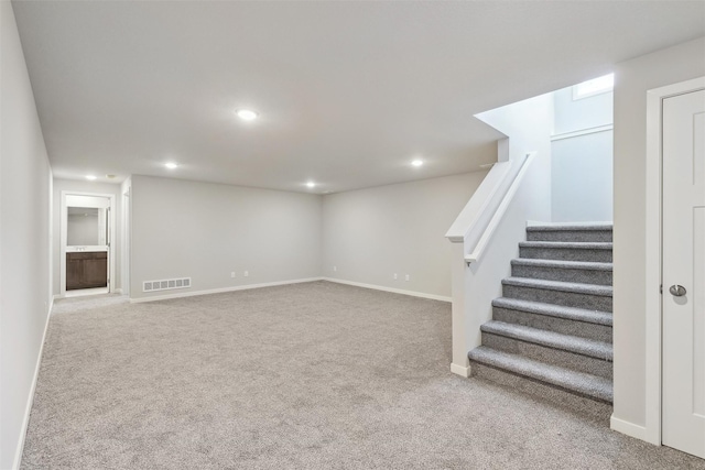 basement featuring light colored carpet