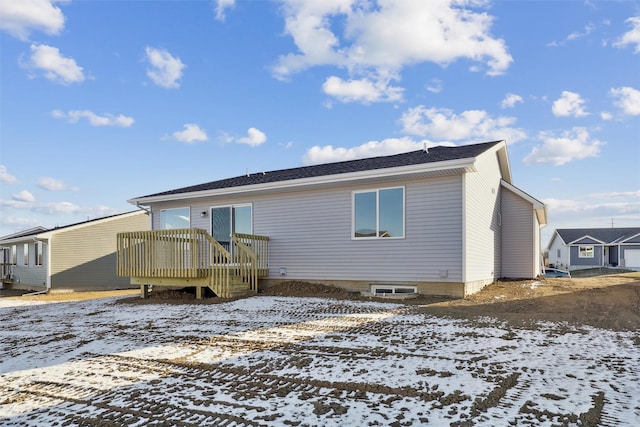 snow covered house with a wooden deck