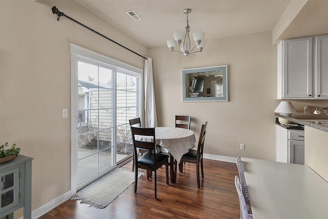 dining space featuring dark hardwood / wood-style flooring and a chandelier