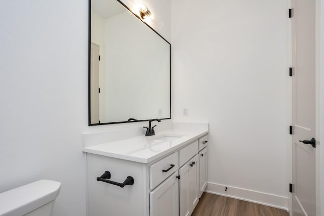 bathroom with vanity, wood-type flooring, and toilet