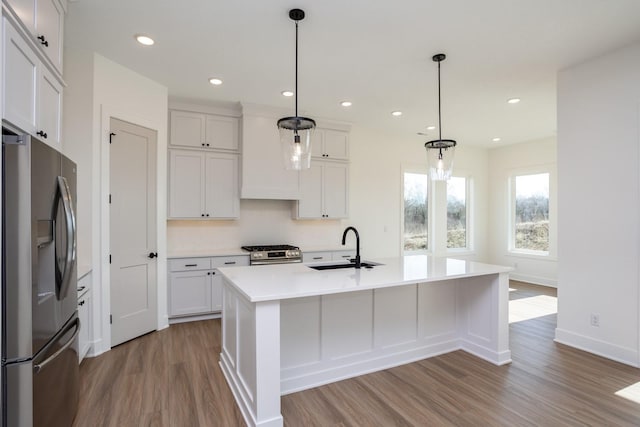 kitchen featuring pendant lighting, sink, a center island with sink, and appliances with stainless steel finishes