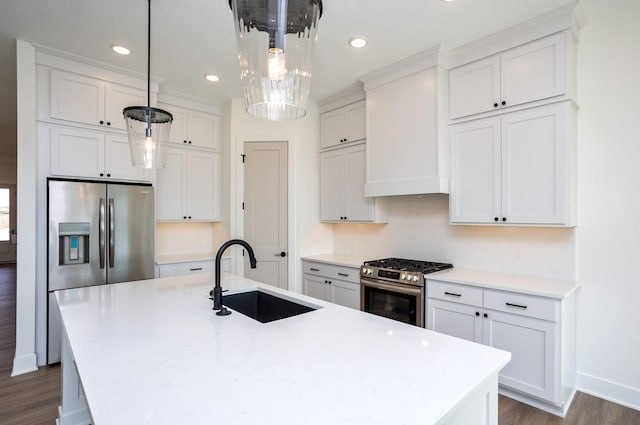 kitchen featuring stainless steel appliances, sink, a center island with sink, and decorative light fixtures