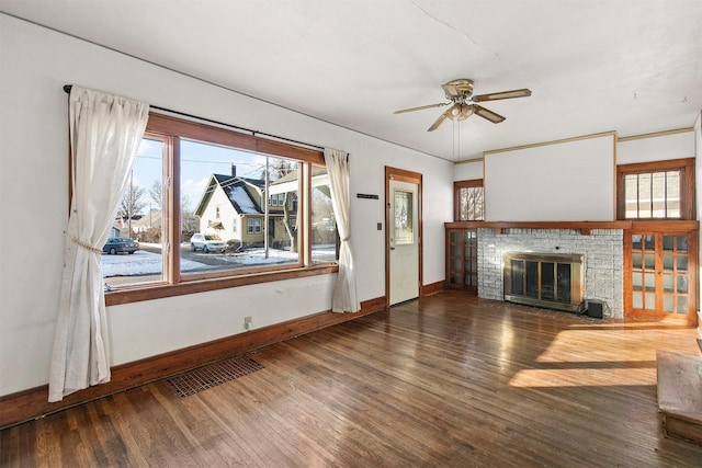 unfurnished living room featuring ceiling fan, dark wood-type flooring, and a fireplace