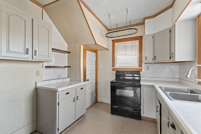 kitchen with black range with electric stovetop, sink, and white cabinetry